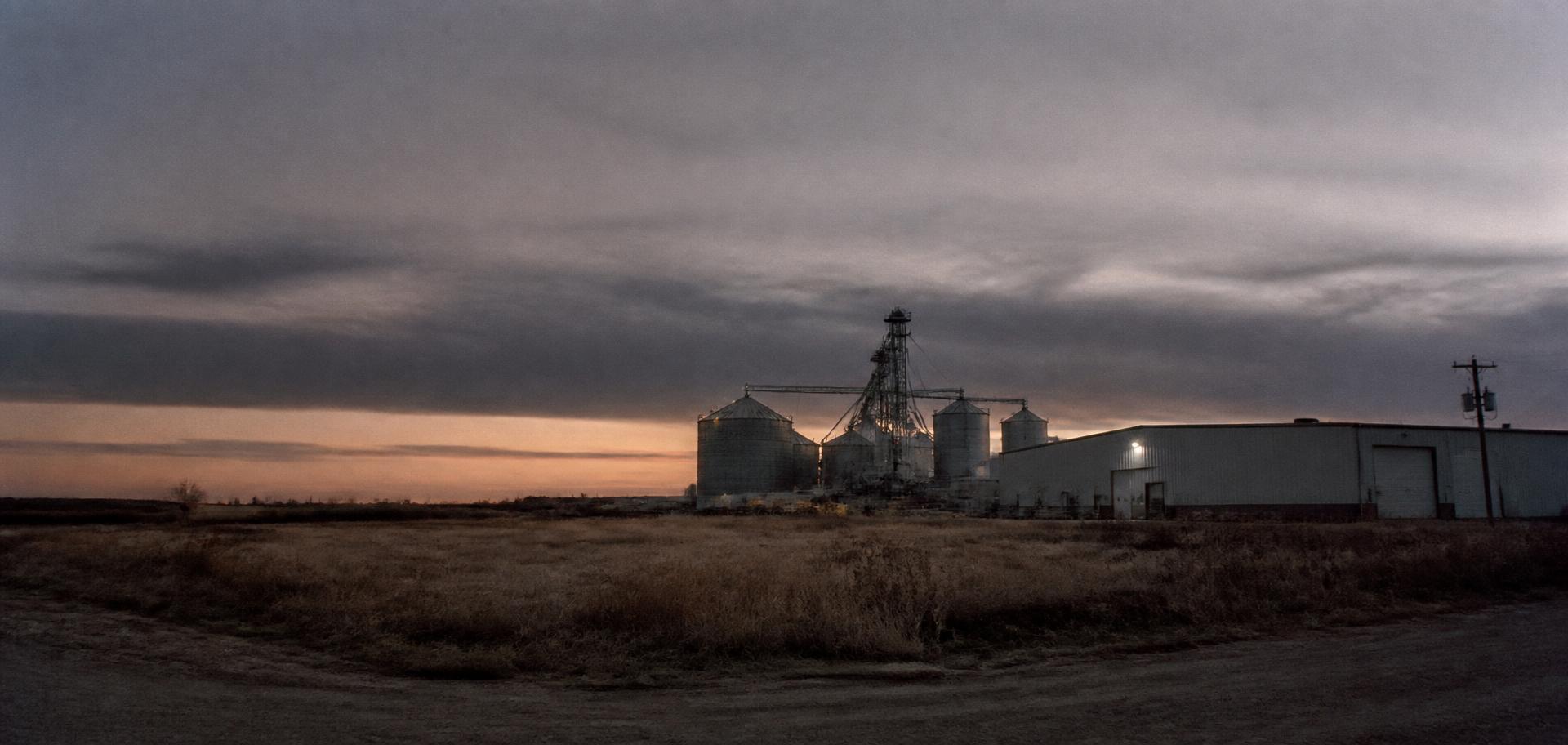 Industrial building and grain silos at dusk